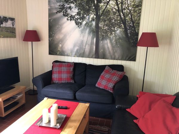 Das gemütliche Wohnzimmer mit Couch, Flach-TV und Leseecke